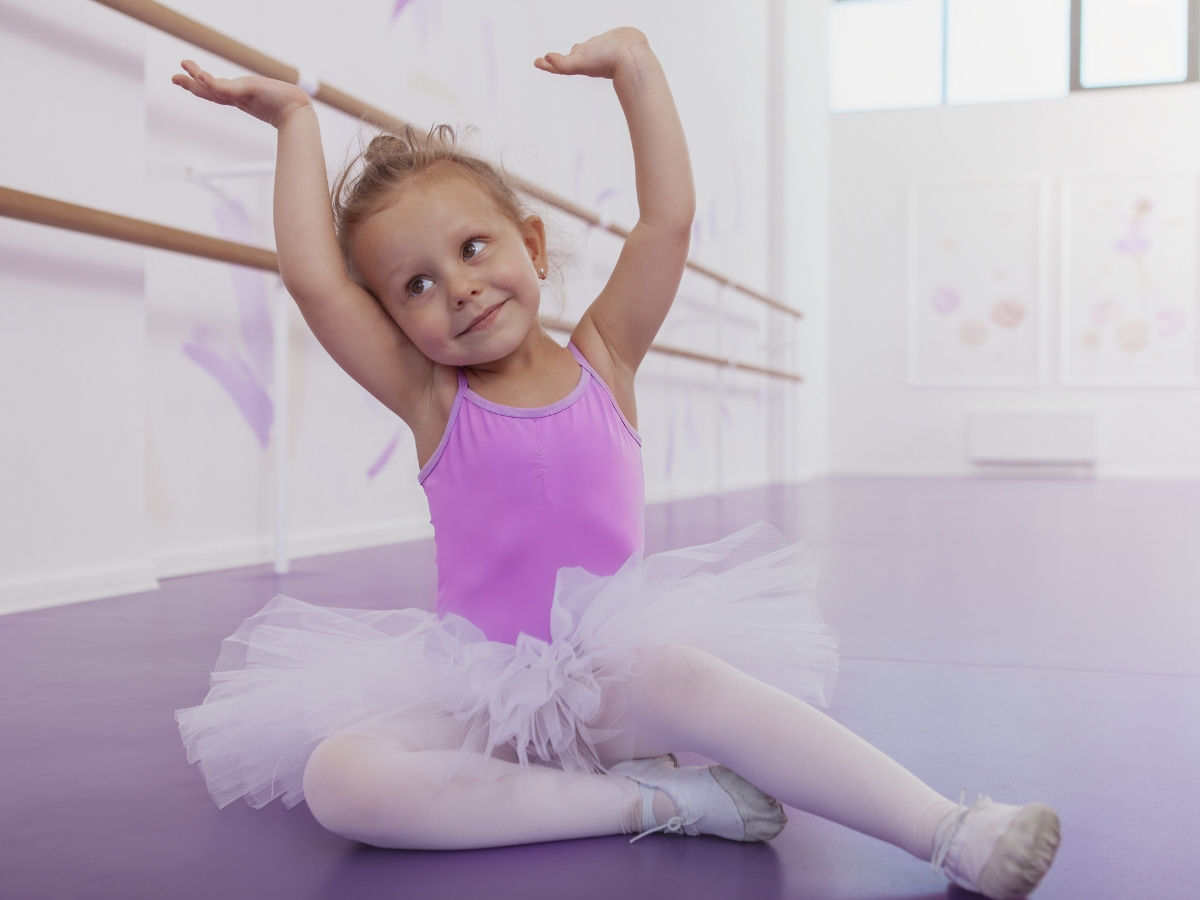 Young ballerina poses in her leotard and tutu